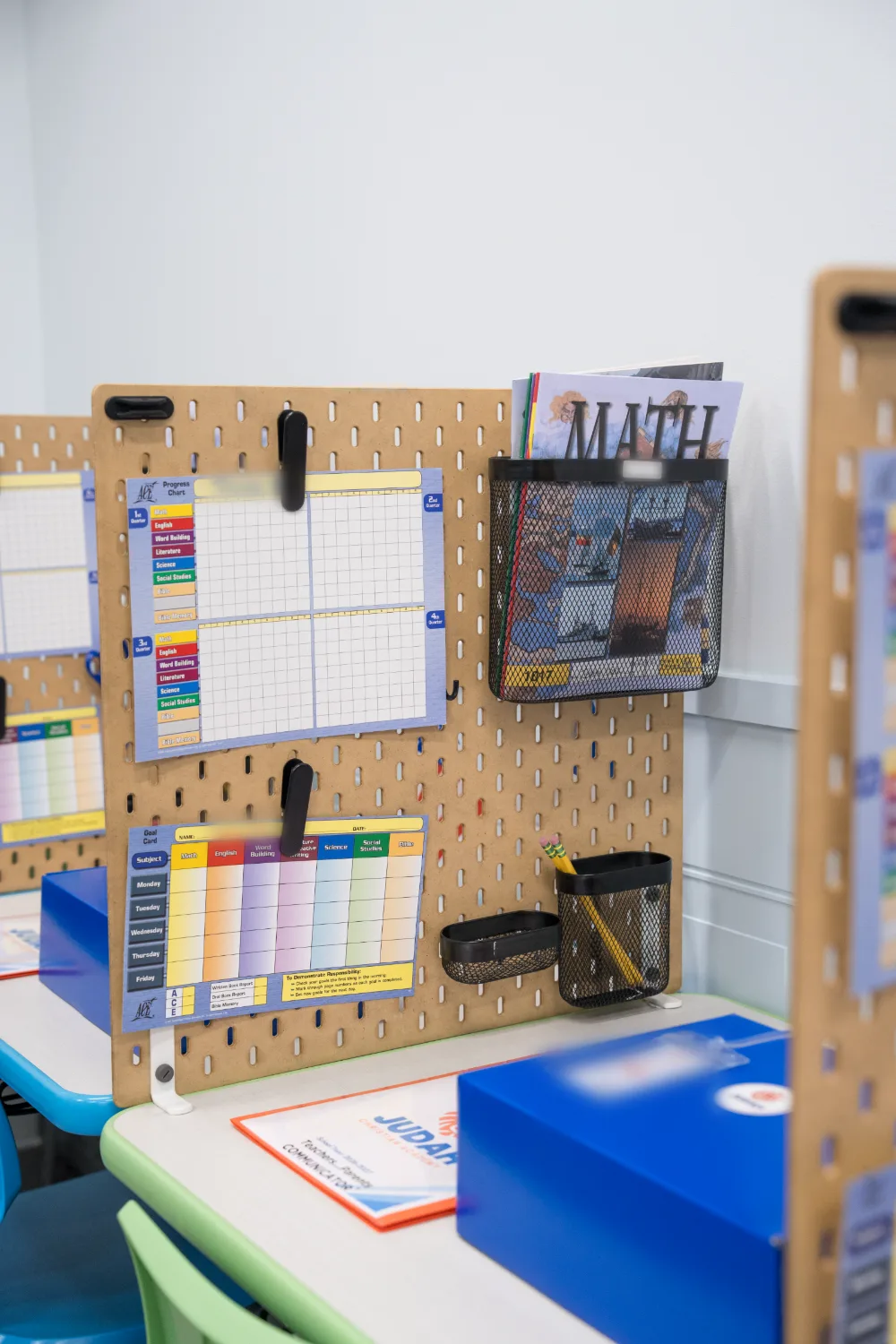A study station with subject materials and organisers on a pegboard.