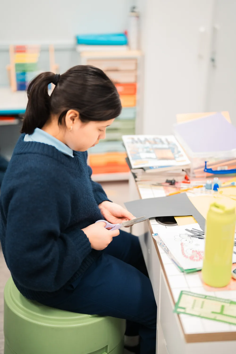 A Judah Christian Academy student working through printed learning materials at their desk.